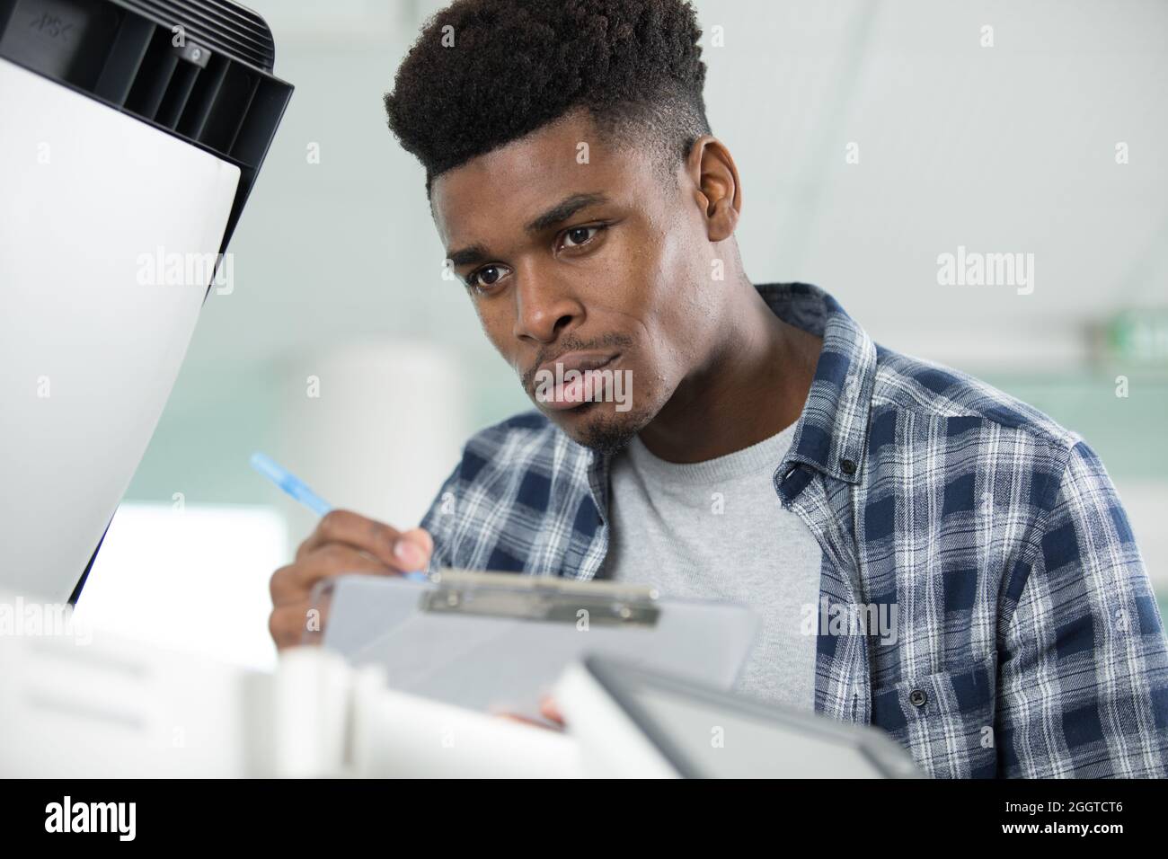 el hombre estaba parado por una fotocopiadora abierta escribiendo en un  portapapeles Fotografía de stock - Alamy