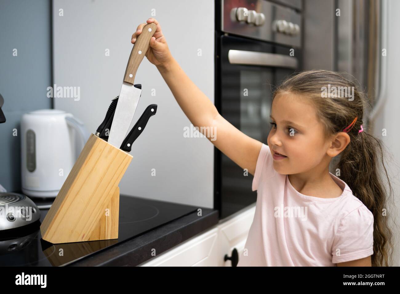 Niño pequeño abre los cajones de la cocina para jugar con utensilios de  cocina dentro niño pequeño en situación peligrosa en casa concepto de  seguridad infantil