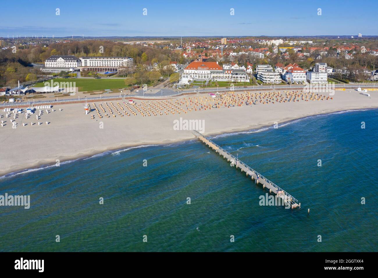 Vista aérea sobre hoteles, embarcadero y sillas de playa de mimbre techadas en la localidad costera de Travemünde, Hanseatic City of Lübeck, Schleswig-Holstein, Alemania Foto de stock