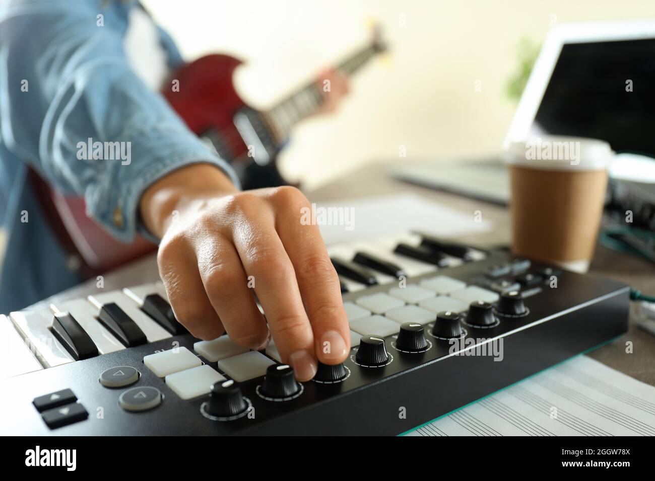 Músico tocando la guitarra eléctrica y el teclado midi, cerca Fotografía de  stock - Alamy
