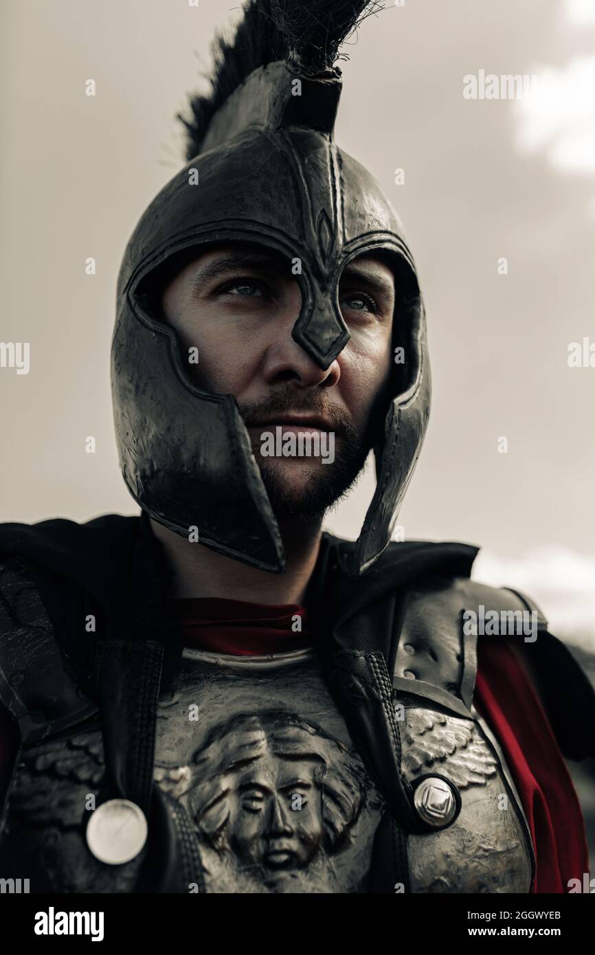 Retrato del antiguo guerrero espartano en armadura y casco contra el fondo  del cielo Fotografía de stock - Alamy