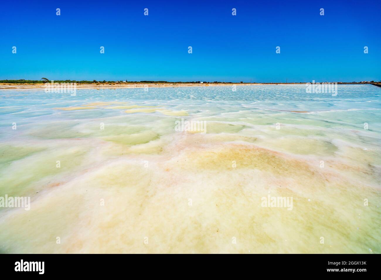 Estanque poco profundo con agua salada utilizado para extraer sal del océano en salines en Faro, Algarve, Portugal Foto de stock