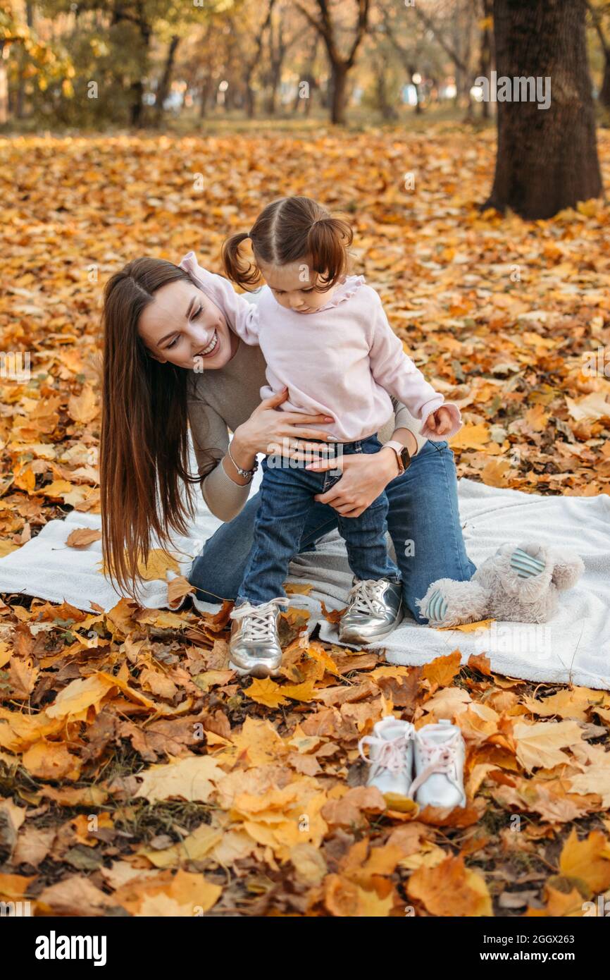 Vestir a niños para juegos al aire libre de otoño. Moda otoñal para bebés,  niños. Ropa y calzado de otoño para actividades al aire libre. Mamá e hija  del bebé p Fotografía