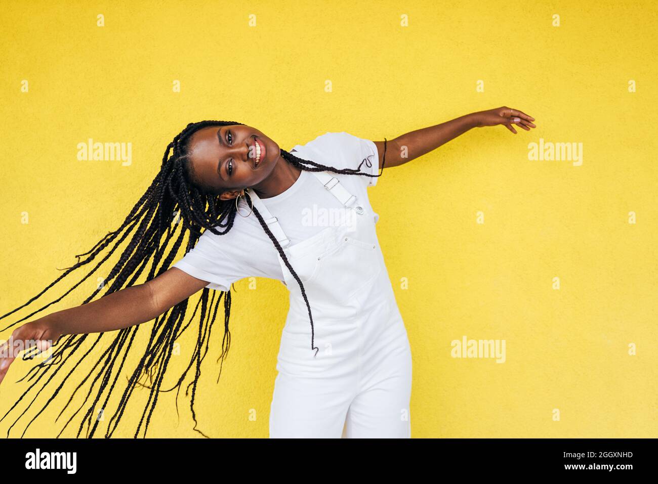 Retrato de una mujer feliz en casuales con trenzas que disfrutan de buen humor al aire libre Foto de stock