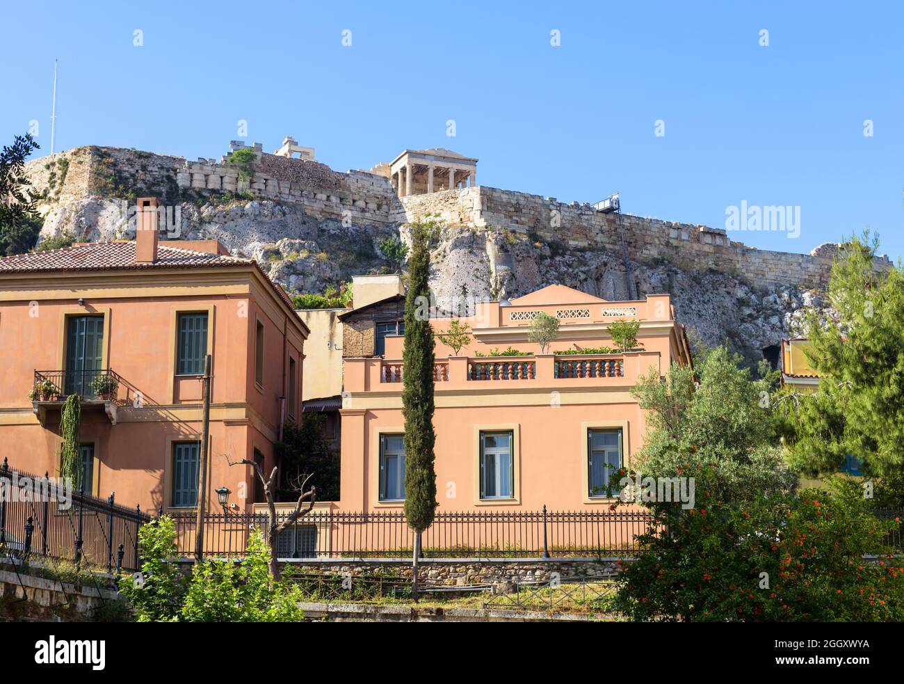 La Acrópolis se eleva sobre casas en el distrito de Plaka, Atenas, Grecia, Europa. Este lugar es una atracción turística de Atenas. Vista del monumento internacional en A Foto de stock