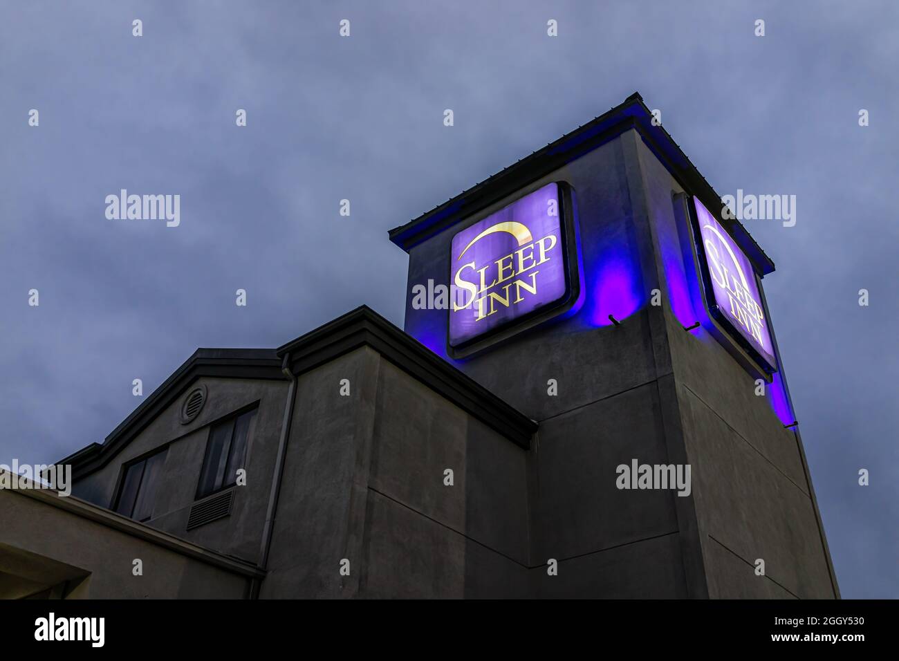 Greenville, EE.UU. - 8 de enero de 2021: Señal exterior en el hotel motel Sleep Inn durante la pandemia de coronavirus covid y la luz azul creposa y el cielo por la noche Foto de stock