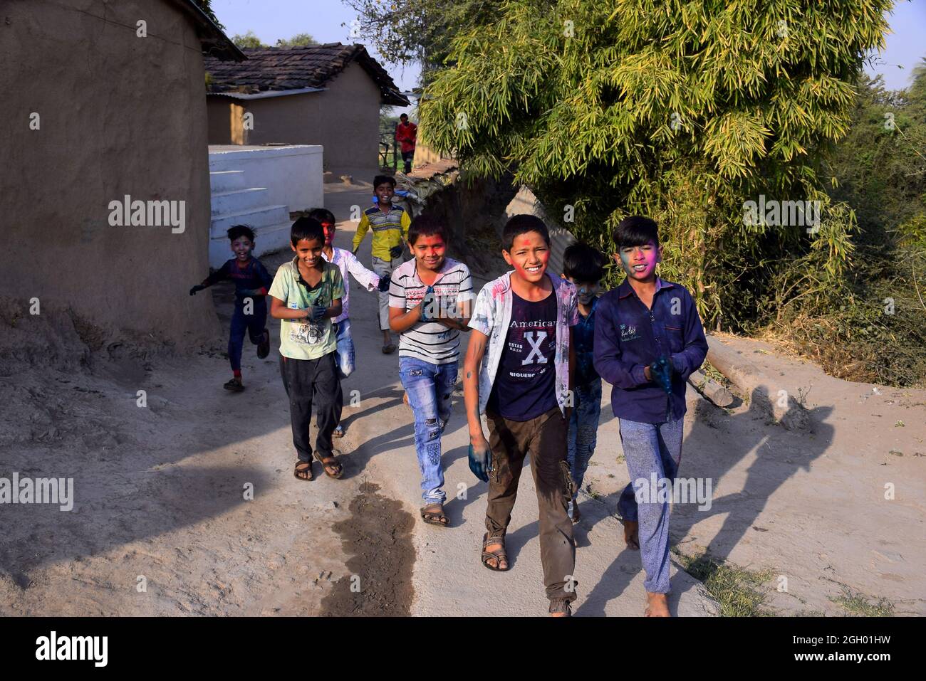 10-03-2020, Dawes, Madhya Pradesh, India, Los niños rurales están jugando en colores en postura feliz, concepto para el festival indio Holi Foto de stock