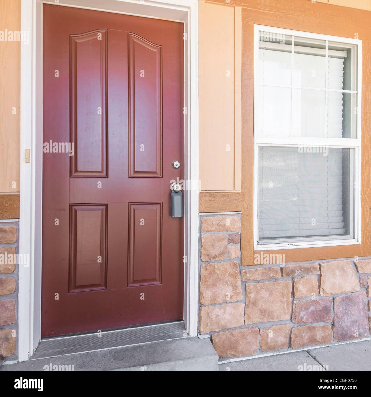 Marco cuadrado Puerta frontal exterior de una casa con media piedra y pared  de madera Fotografía de stock - Alamy