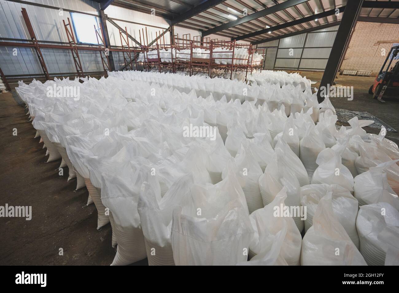 Gran almacenamiento con sacos de plástico blanco que van a transferir Foto de stock