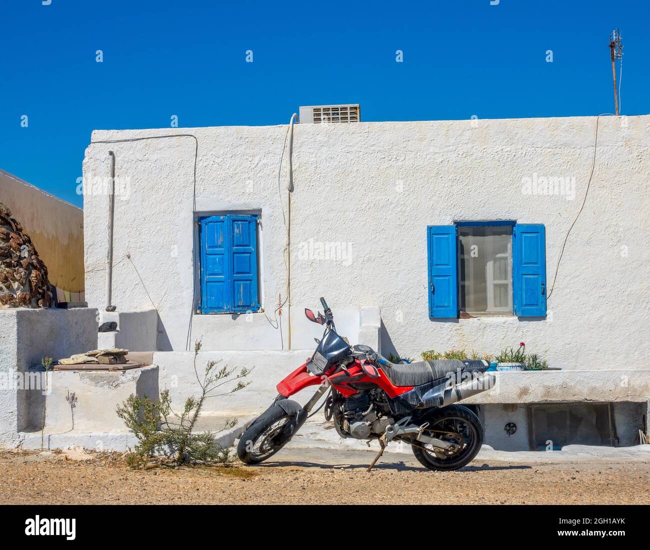 Grecia. Oia ciudad en la isla de Santorini. Moto roja en frente de la casa. Foto de stock