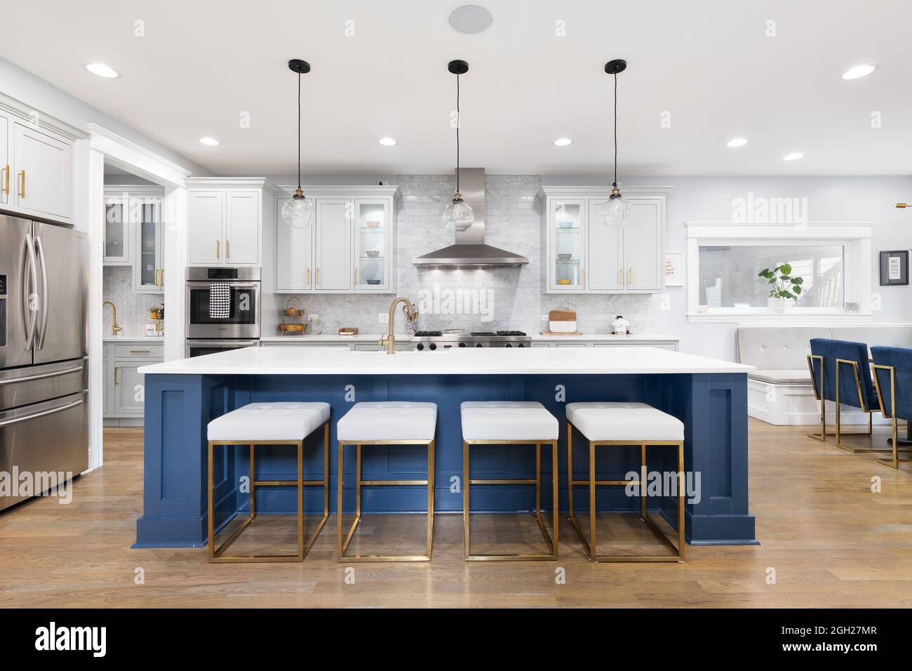 Una hermosa cocina moderna con armarios grises y azules, electrodomésticos  Viking de acero inoxidable, herrajes dorados y luces de vidrio colgando  sobre la isla Fotografía de stock - Alamy