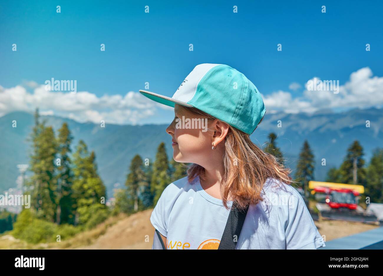 Retrato de una hermosa niña en un impermeable y una gorra blanca contra el  fondo de las hermosas montañas Karpatsky. Concepto de viaje, actividades de  ocio Fotografía de stock - Alamy