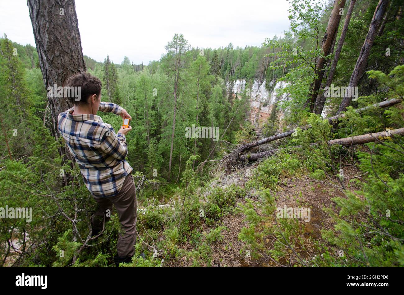 Junio, 2021 - Pinega. Un hombre en el borde de un acantilado. Reserva Pinezhsky. Turismo ecológico. Rusia, región de Arkhangelsk Foto de stock