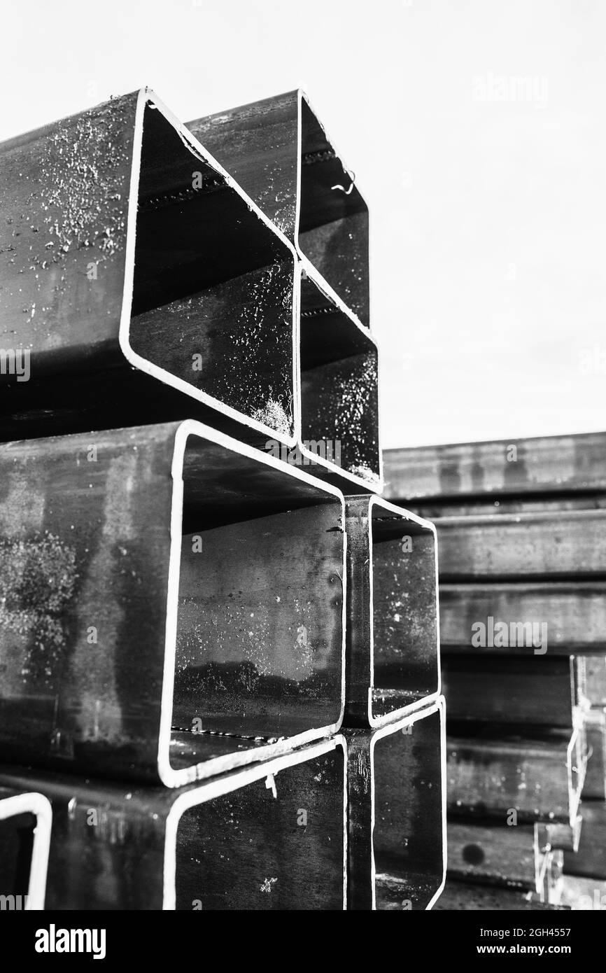 Productos metálicos laminados apilados, tuberías de acero con sección transversal rectangular, foto en blanco y negro de primer plano Foto de stock