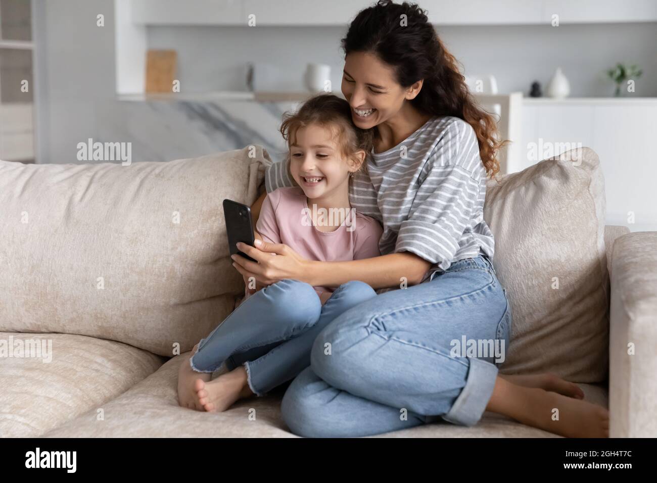 Feliz madre joven y niño pequeño utilizando aplicaciones de teléfono móvil. Foto de stock