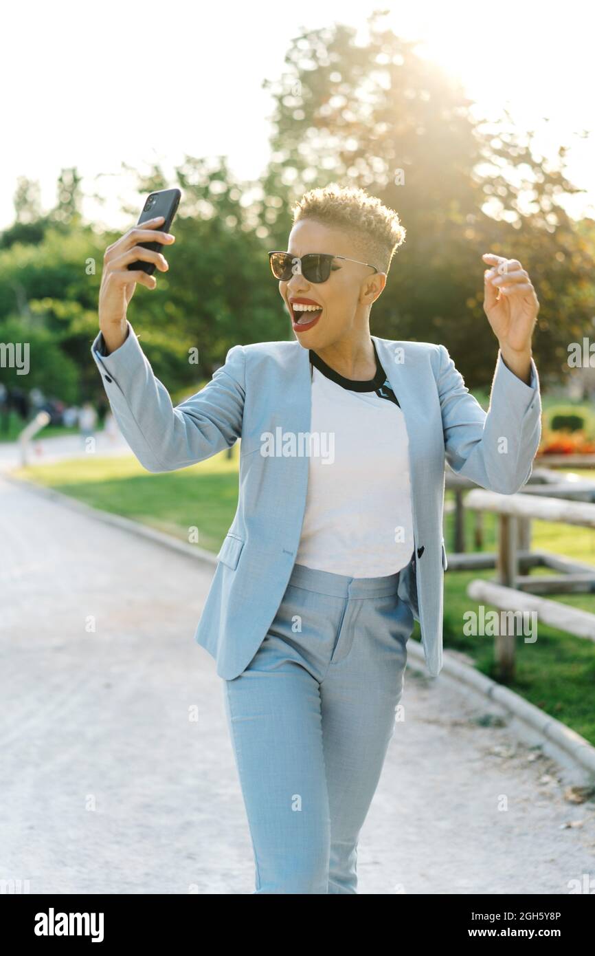 Contenido Mujer africana americana madura en gafas de sol modernas teniendo  chat de vídeo en el teléfono móvil en el parque en la parte trasera  iluminada Fotografía de stock - Alamy