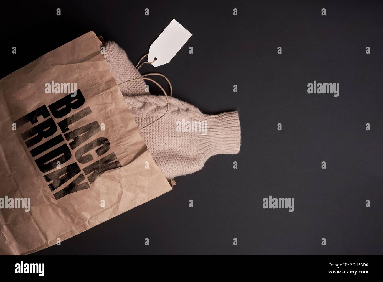 Concepto de viernes negro. Un suéter de punto cálido en la bolsa de la  compra. Ropa de invierno comprada en Black Friday Fotografía de stock -  Alamy