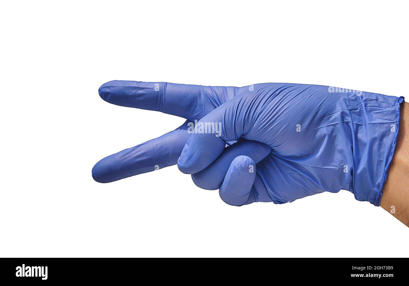 Un médico con un guante azul, pone sus dedos en forma de tijeras, indicando un corte, mientras explica cómo se realizará la cirugía. Foto de stock