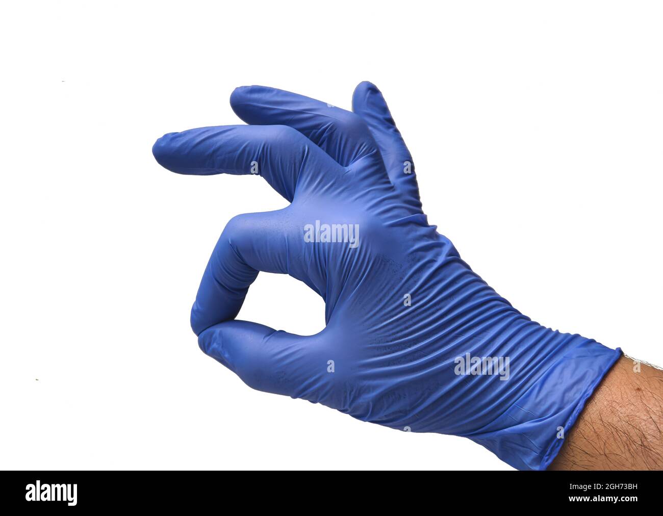 Un doctor con un guante azul, pone sus dedos con un gesto de aceptación y confirmación dando el avance. Foto de stock