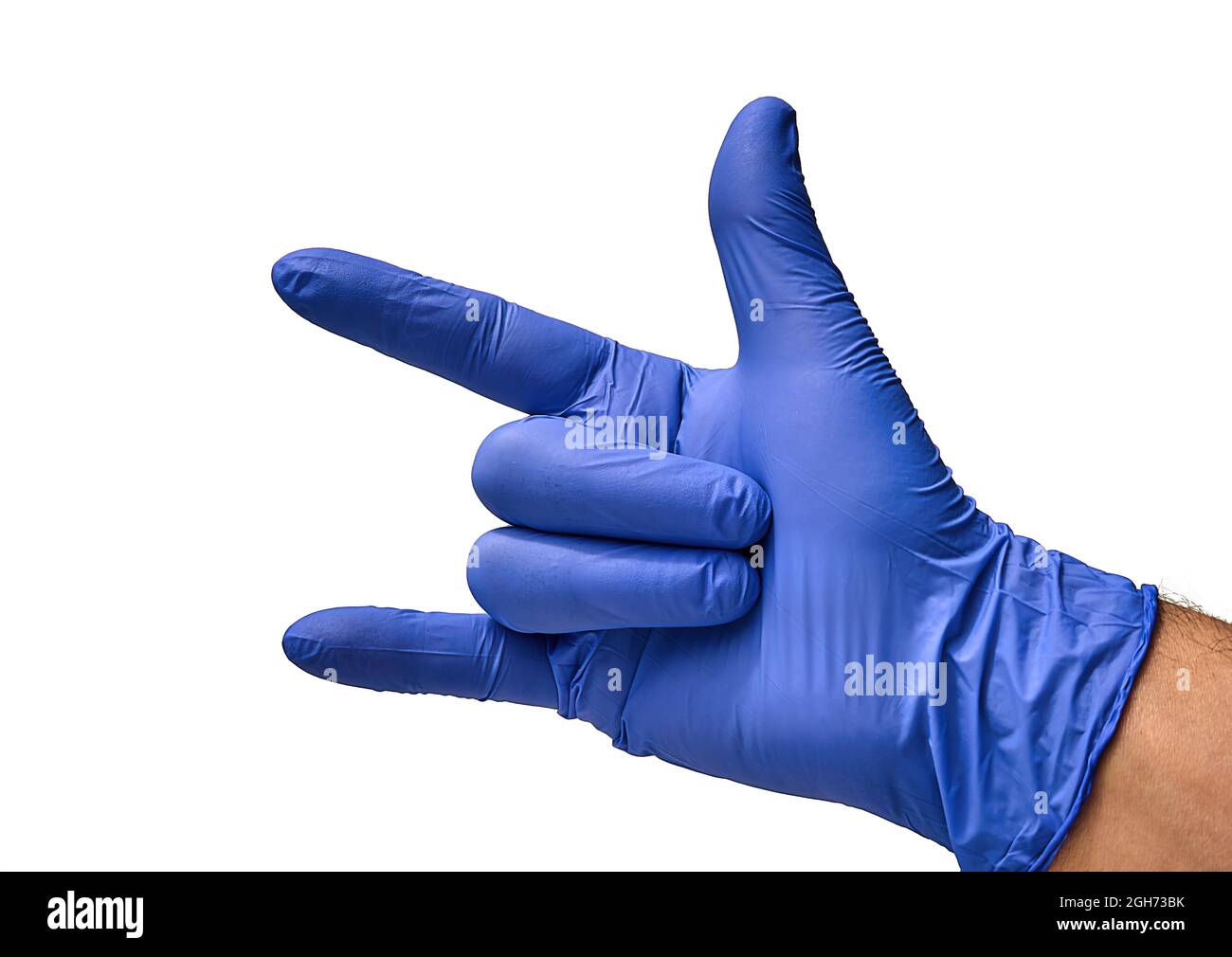 Un médico que usa un guante azul, con un puño cerrado y tres dedos abiertos indica que está disfrutando de música rock, mientras realiza la cirugía. Foto de stock