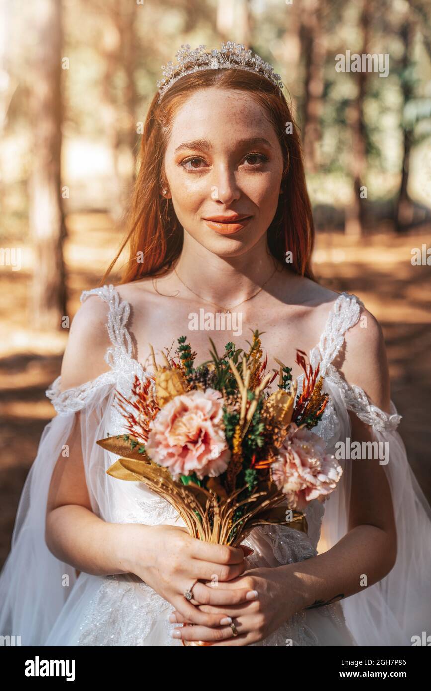 Novia con vestido blanco de boda en el bosque que sostiene colorido y secado ramo de bodas. . Fotografías de alta calidad Foto de stock