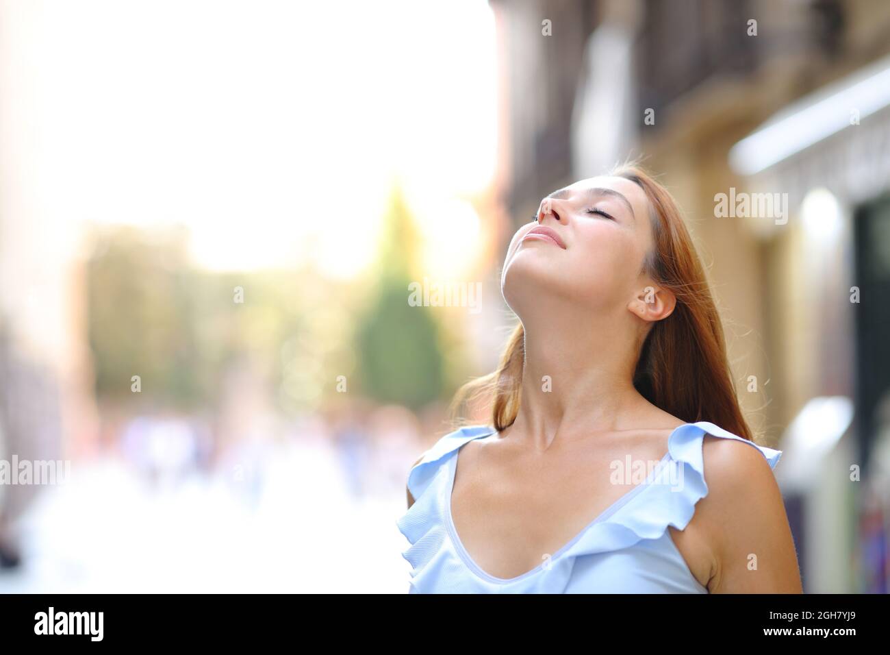 Una mujer relajada está respirando aire fresco en la calle Foto de stock