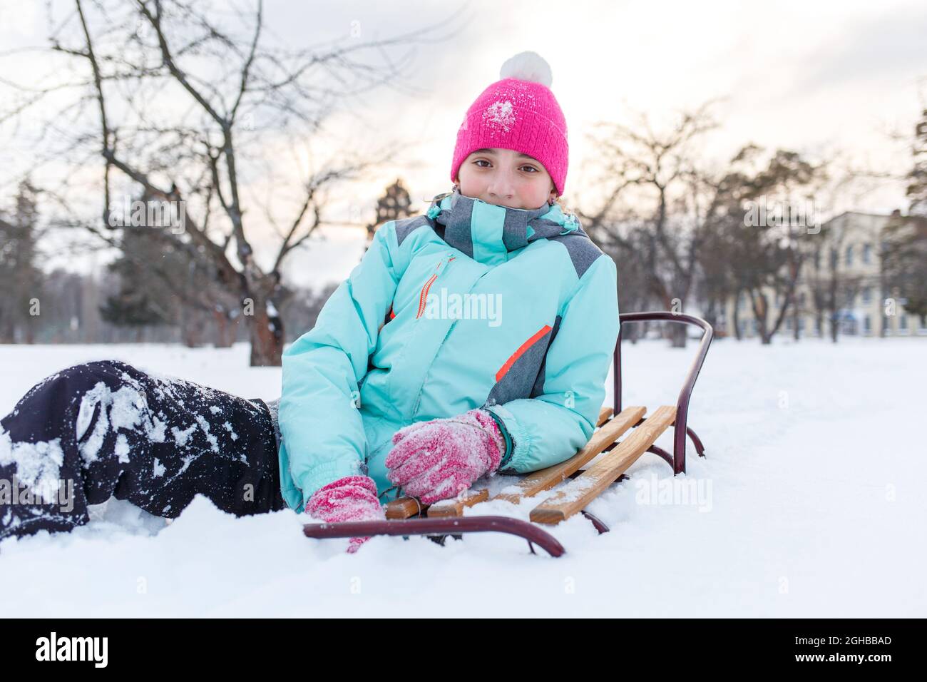 Teengae niña divertirse jugando con el trineo en la nieve en invierno. Foto de stock