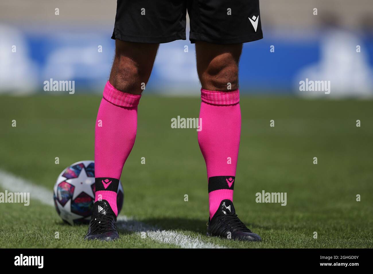 Detalles de los calcetines rosa Macron del árbitro y las botas de fútbol Adidas con un balón oficial en el marco durante el partido Liga Juvenil de la