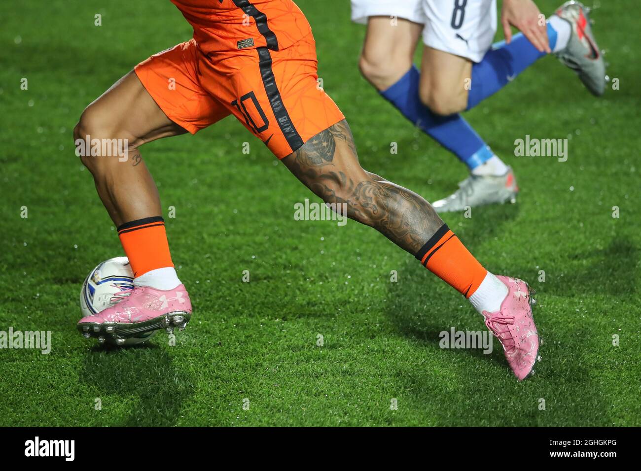 Las piernas tatuadas y las botas de color rosa bajo la armadura de Memphis Depay de los Países como él dribbles la bola pasado. Jorginho de Italia durante el partido de