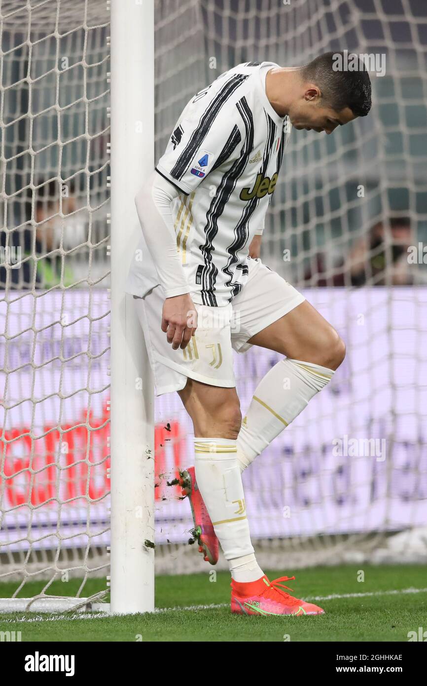 Cristiano Ronaldo de la Juventus golpea sus botas contra la base del puesto  de gol para despejar los tacos de suelo durante el partido de la Serie A en  el estadio Allianz