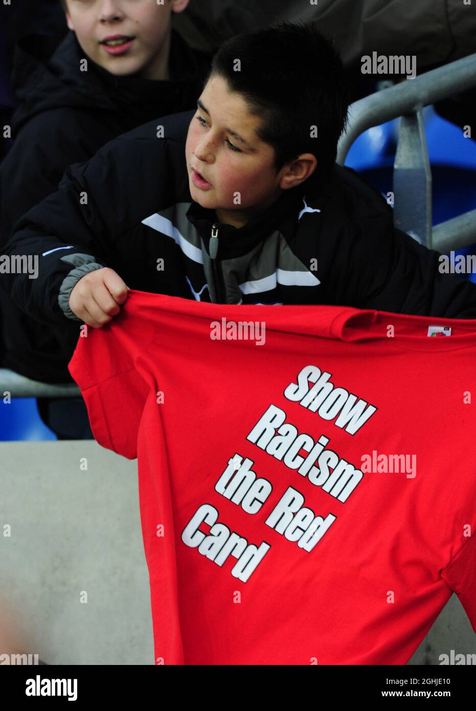 Un joven fan sostiene una camiseta anti-racismo durante el partido amistoso Internacional entre Gales y Escocia en el Cardiff City Stadium, Gales. Foto de stock