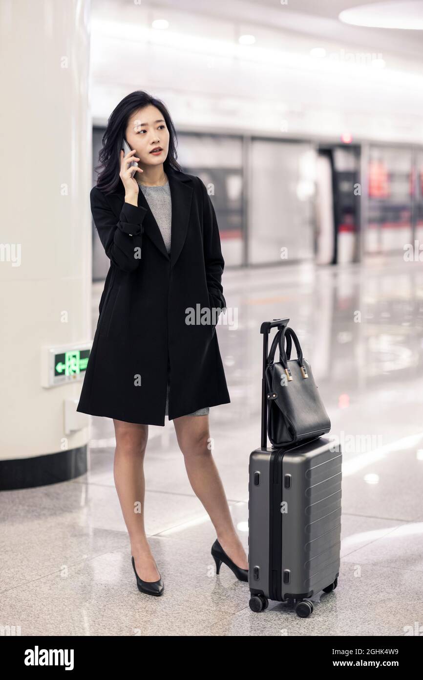 Joven mujer de negocios usando smartphone en la estación de metro Foto de stock