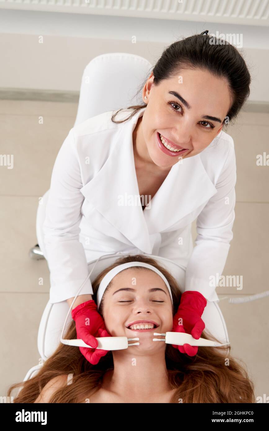 https://c8.alamy.com/compes/2ghkpc0/mujer-hermosa-en-clinica-de-spa-recibiendo-tratamiento-facial-electrico-estimulante-de-terapeuta-primer-plano-de-la-cara-femenina-joven-durante-la-terapia-de-microcorriente-2ghkpc0.jpg