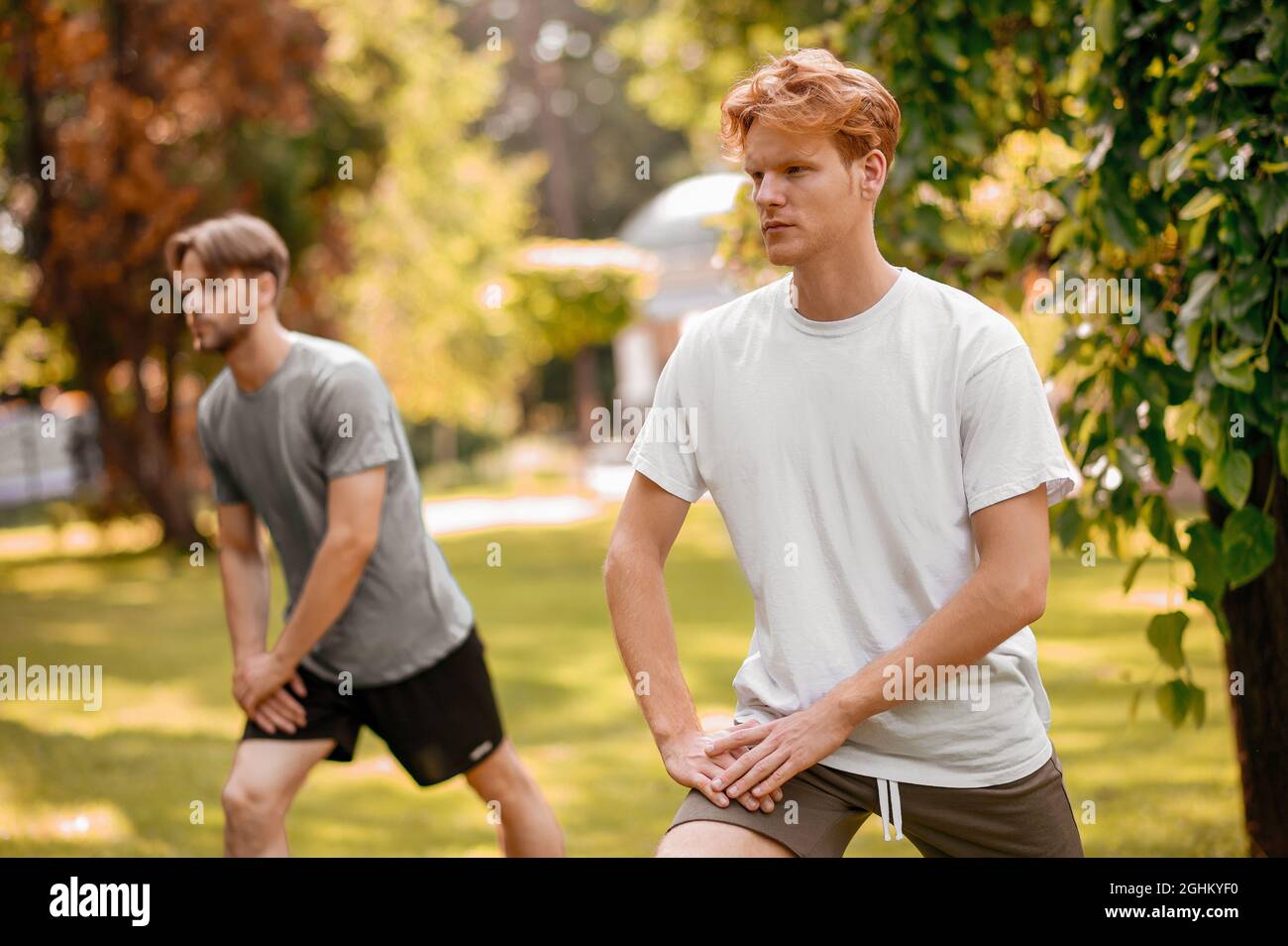 Chicos en ropa deportiva haciendo ejercicios en la naturaleza Fotografía de  stock - Alamy