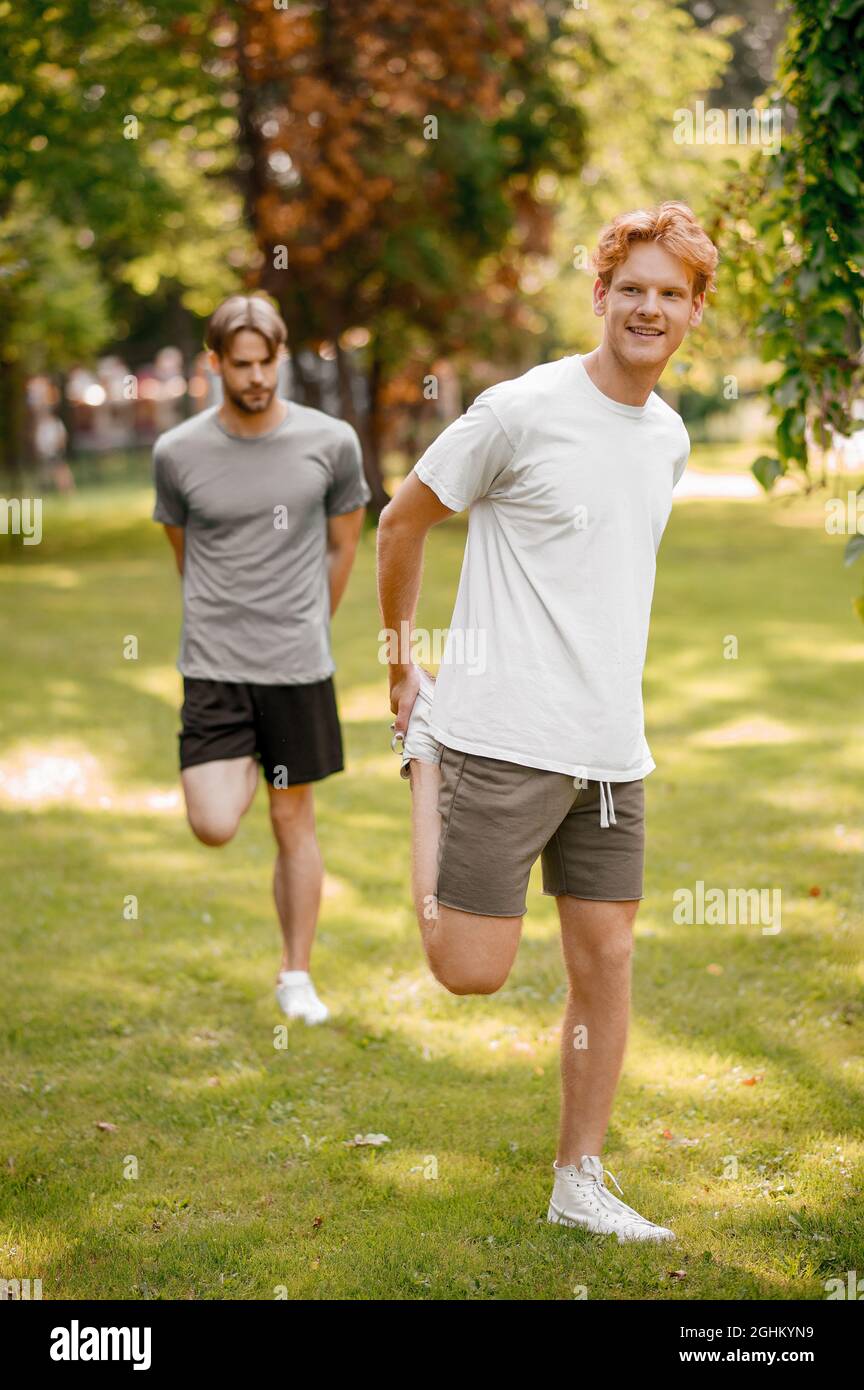 Dos chicos en ropa deportiva calentándose en el césped Fotografía de stock  - Alamy