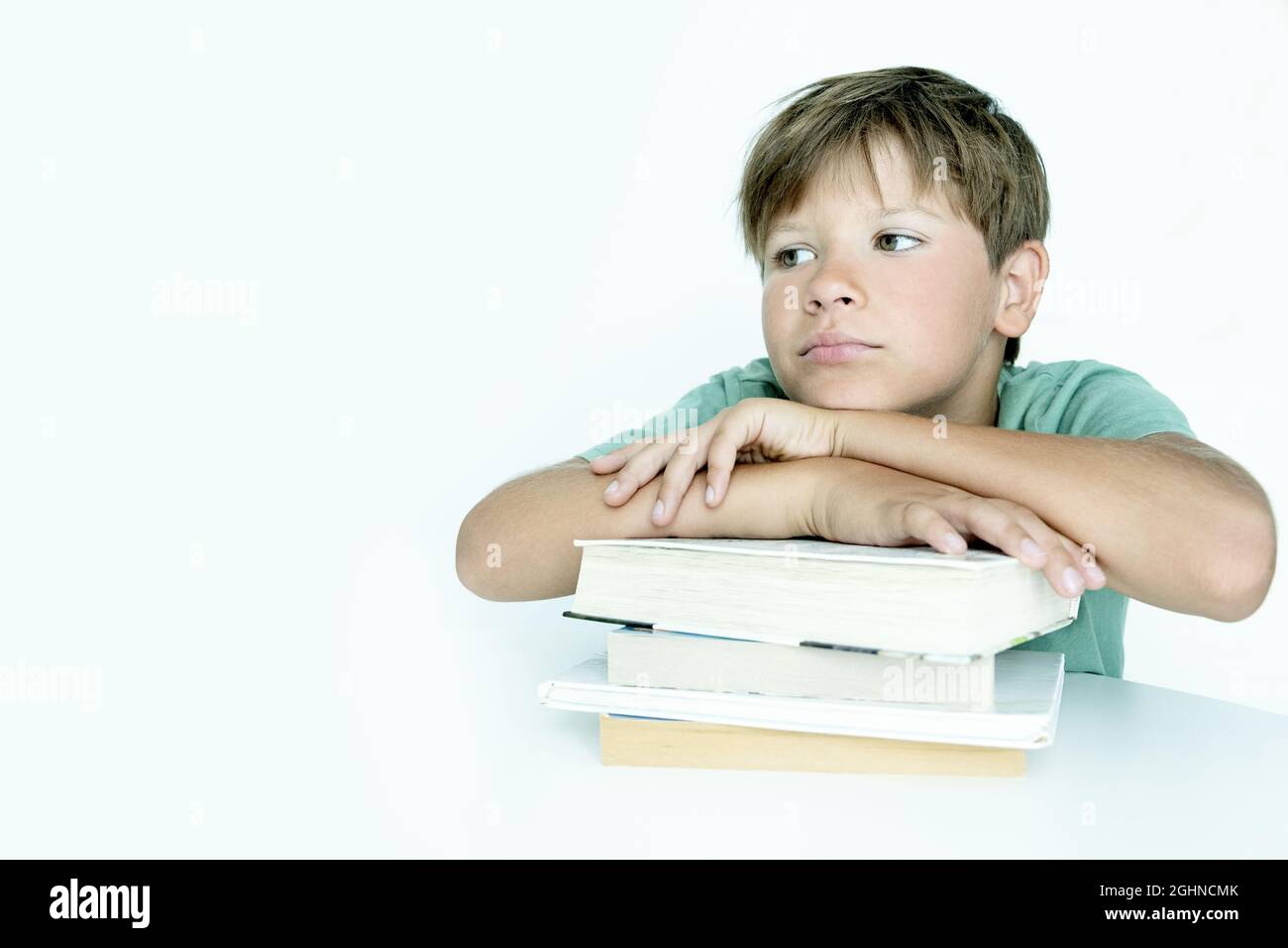 Niño triste con libro hace la tarea de la escuela. Regreso a la escuela. Niño infeliz con libros de texto. Distancia learnin Foto de stock