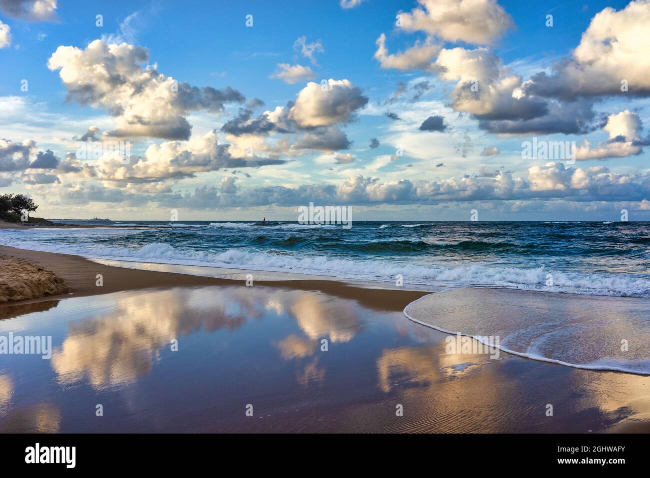 Reflexiones sobre las nubes al atardecer, Moffat Beach, Queensland, Australia Foto de stock