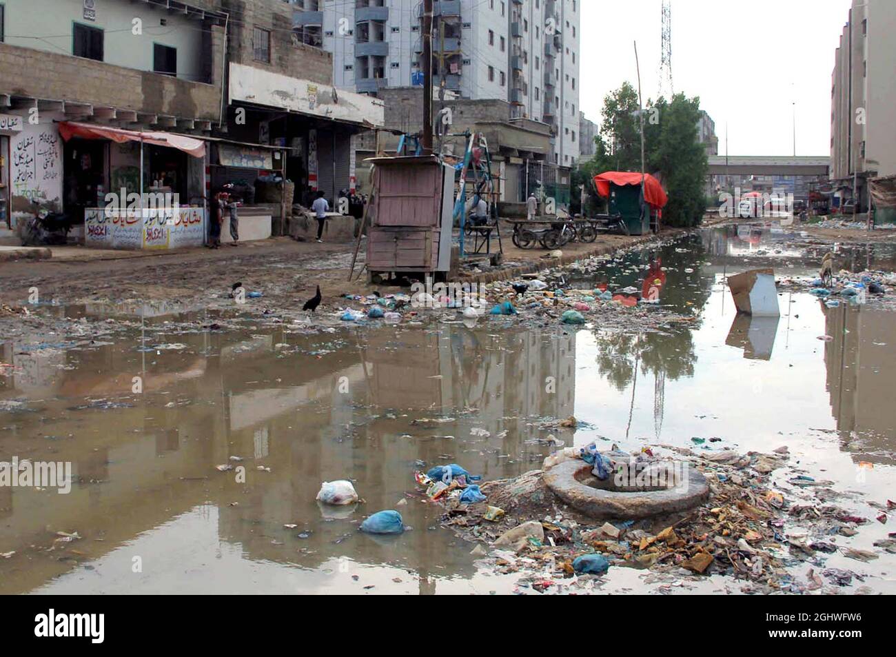 Calle agitada llena de basura y agua de alcantarillado que causa ambiente antihigiénico y crea problemas para los viajeros, mostrando negligencia de las autoridades interesadas, detrás del edificio del Hospital de Servicio situado en la zona de la ciudad de Surjani de Karachi el martes, 07 de septiembre de 2021. Foto de stock