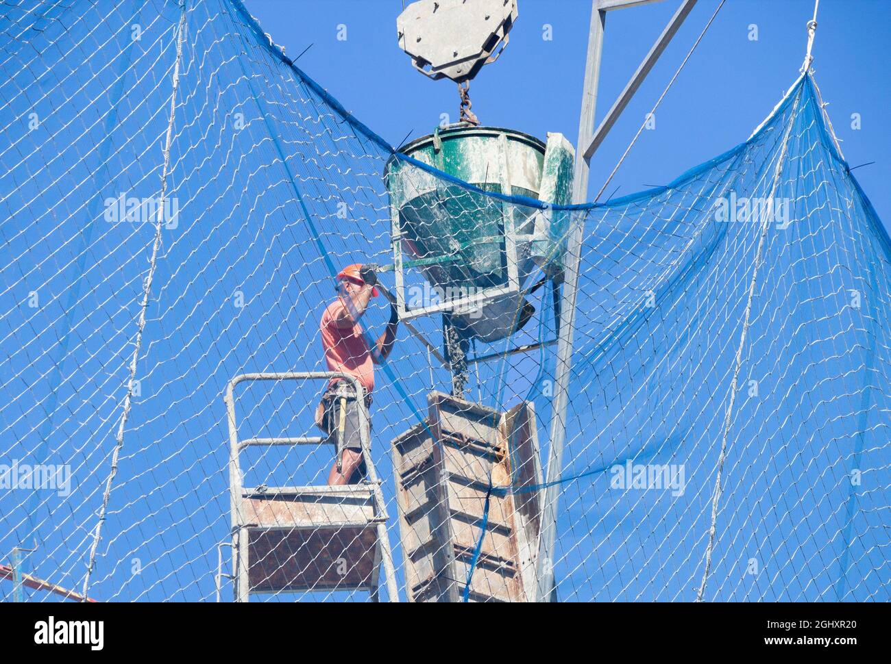 trabajador, trabajador, vertiendo hormigón en el sitio de la construcción. Foto de stock