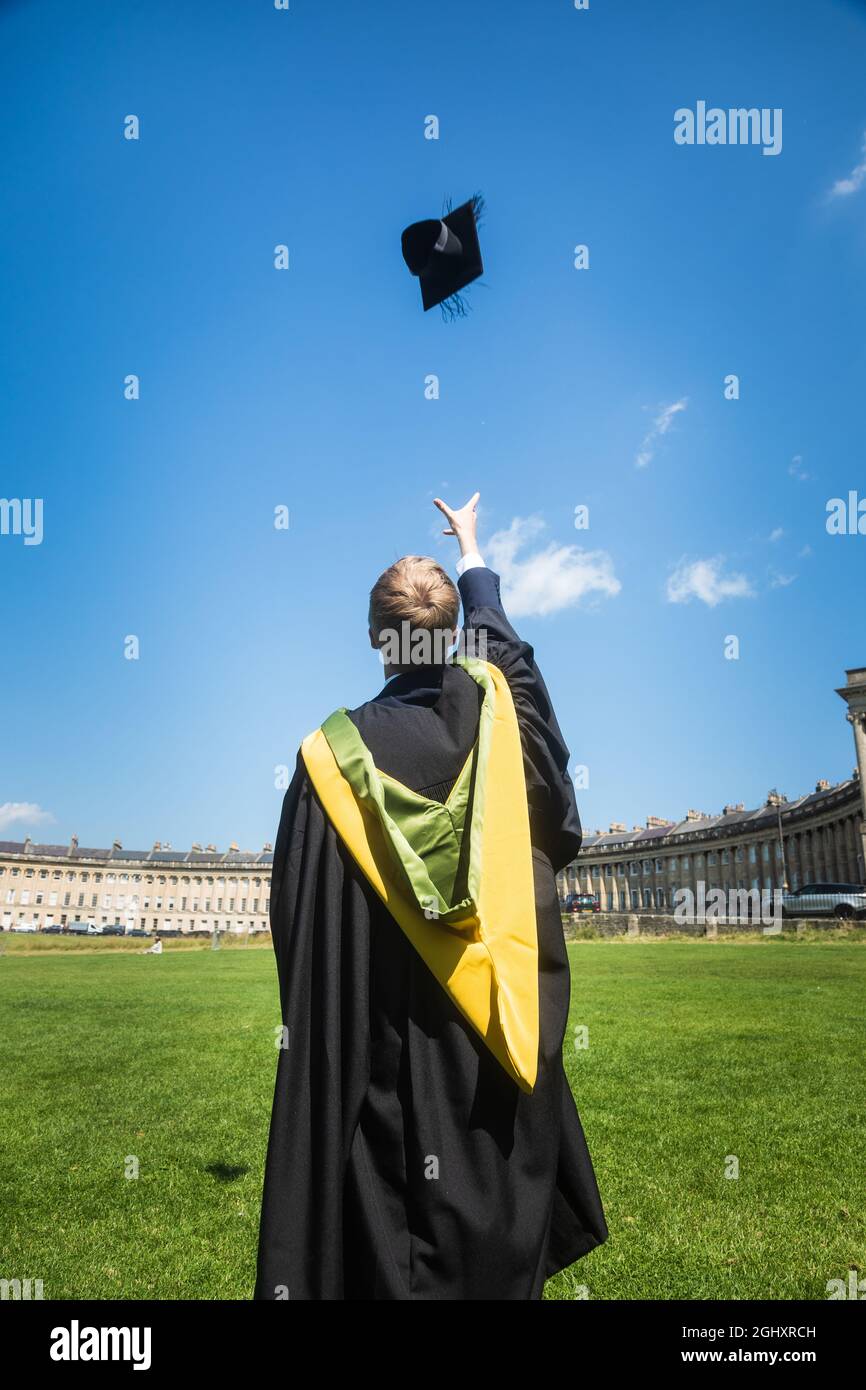 Graduado de la Universidad de Bath con bata de graduación y mesa de mortero de lanzamiento Foto de stock