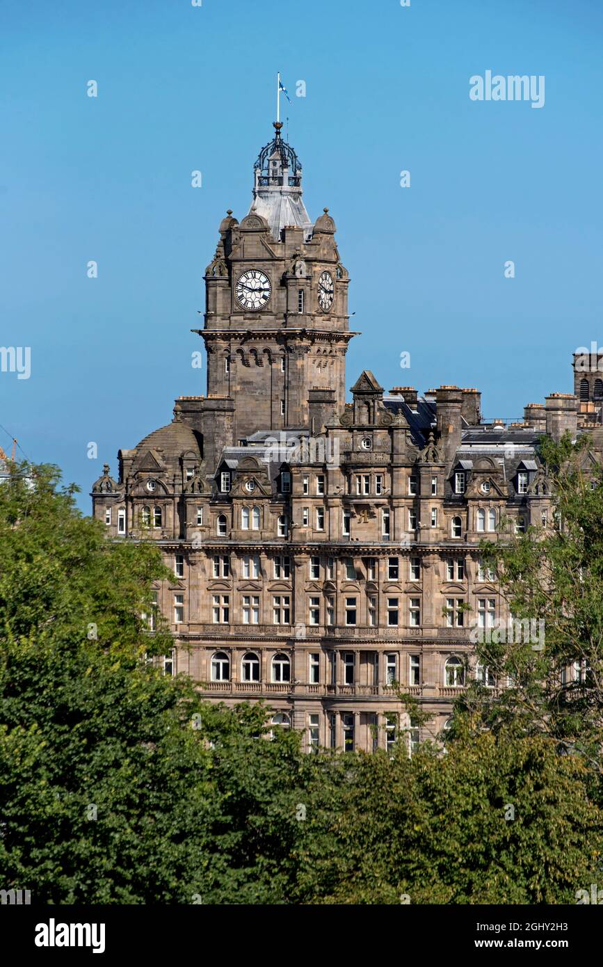 El campanario del Hotel Balmoral visto a través de los árboles en Princes Street Gardens, Edimburgo, Escocia, Reino Unido. Foto de stock