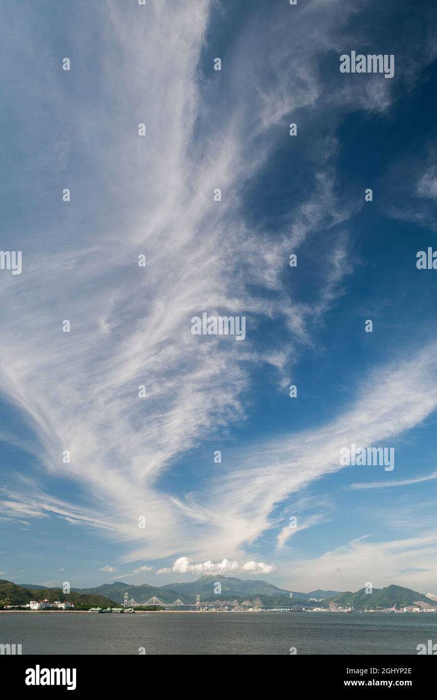 Cielo azul de gran angular con nubes cirrus sobre los puentes Tsing Ma y Ting Kau, visto desde Peng Chau, una isla al aire libre de Hong Kong Foto de stock