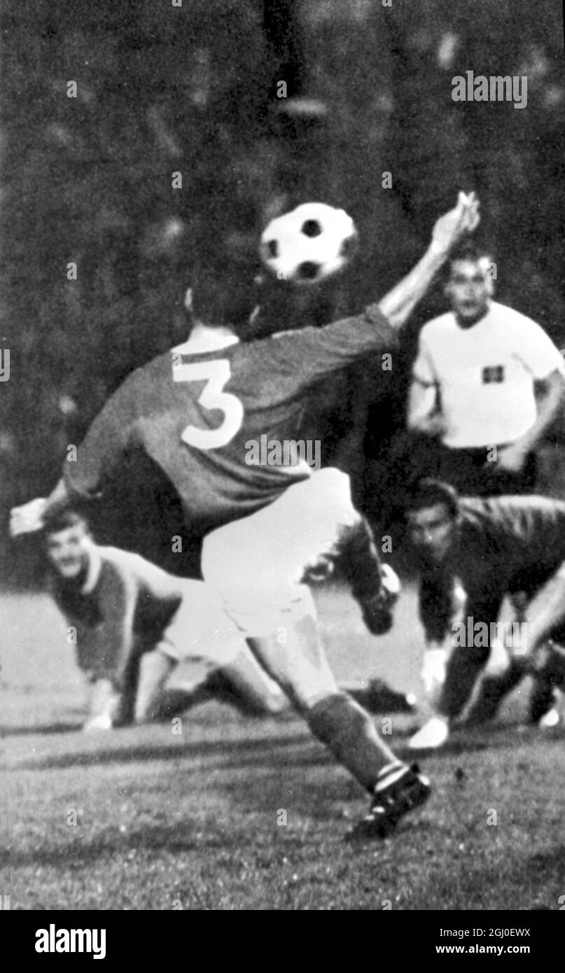 Hamburg contra Manchester United Mate of Hamburg (fuera de la imagen) marca el gol igualador contra Manchester United. Dunne (No.3), Dave Gaskell, el (portero del Manchester Utd), y Kurt (Hamburgo) se muestran merodeando cuando la bola pasa a la red. 12th de agosto de 1964. Foto de stock