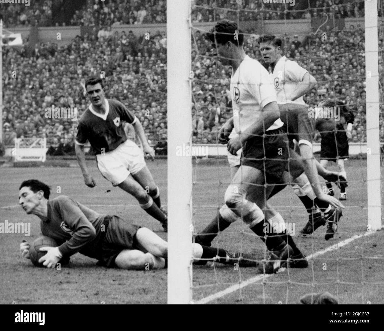 1961 FA Cup Tottenham Hotspur contra Leicester City. Bill Brown, el portero de Spurs bucea a lo largo de todo para hacer un ahorro, pero su línea de meta es bien defendida por los defensores durante el partido en Wembley. 6th de mayo de 1961 Foto de stock