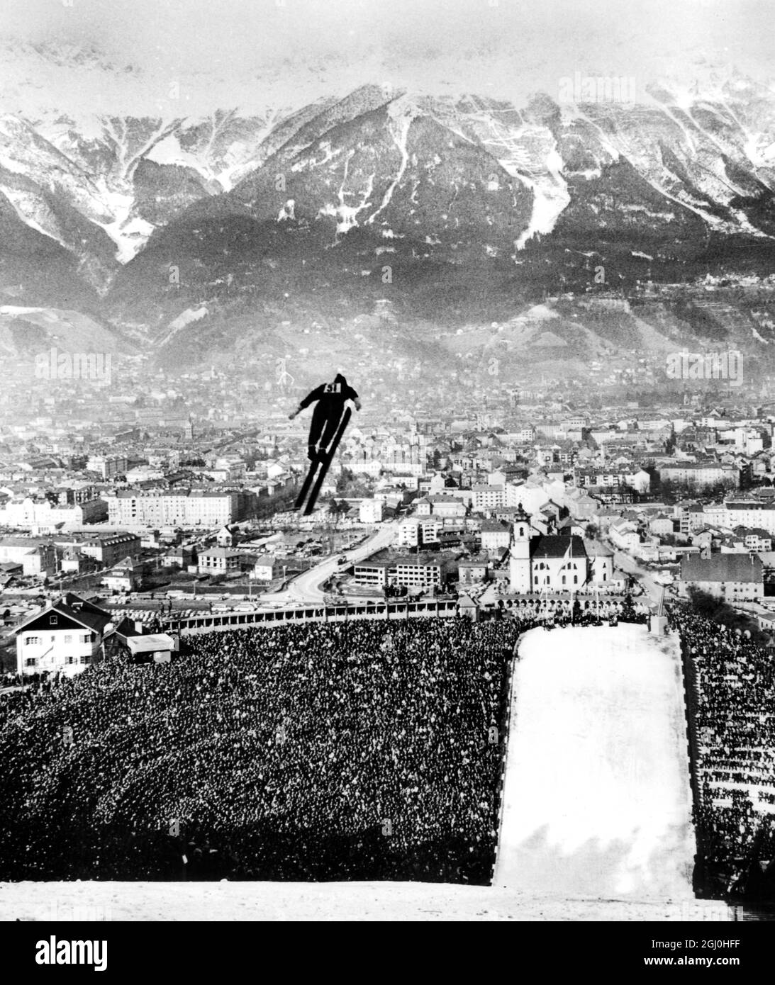 1964 Juegos Olímpicos de Invierno - Innsbruck, Austria Visto por 80.000 espectadores Un competidor - uno de cincuenta y dos de quince naciones - vuela a través del aire después de despegar de una plataforma de 480 pies de altura, Durante el salto de esquí de 80m en Innsbruck - el evento final de los IX Juegos Olímpicos de Invierno. Los competidores despegar a velocidades de aproximadamente 60mph para navegar durante tres segundos o así a través del aire - alcanzando velocidades de más de 67 mph - y finalmente aterrizar hasta 313 pies de distancia del lugar donde habían perdido contacto con el suelo. - 10th Febrero 1964 - ©Topfoto Foto de stock