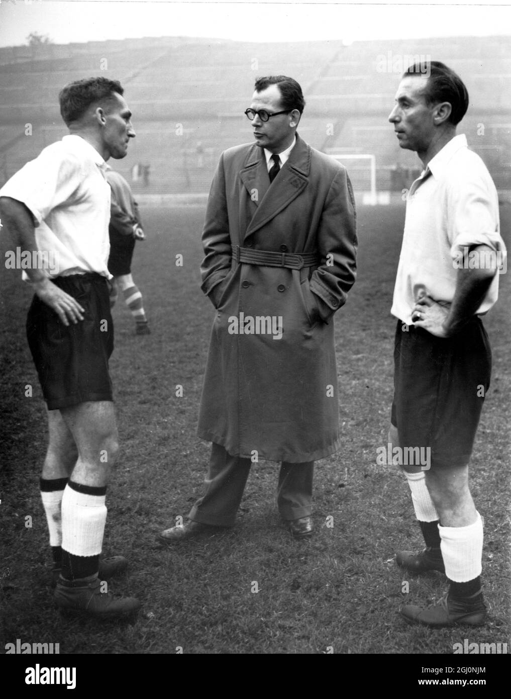 Roy Bentley de Chelsea (izquierda) y Stanley Matthews de Blackpool en conversación con el gerente Walter Winterbottom en Charlton cuando los 17 jugadores de los cuales el equipo de Inglaterra para conocer Gales será elegido, informó para el entrenamiento . 1st de noviembre de 1954 Foto de stock