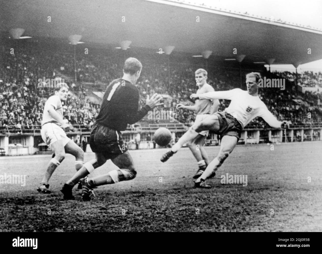 Inglaterra venció a Finlandia en la Copa Mundial de Fútbol de 1966 Helsinki, Finlandia : llegando al tercer gol. Izquierda, Reijo Kanerva, portero, Martti Halme; Sepbo Kilponen y Jack Charlton, aquí el 26th de junio cuando Inglaterra venció a Finlandia 3-0 en Helsinki. 26 de junio de 1966 Foto de stock