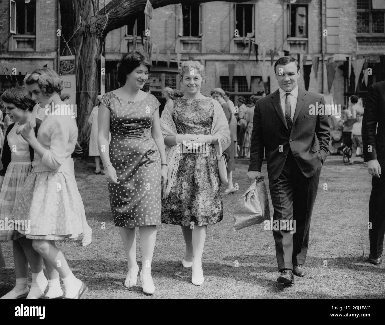 Marjorie Thomson , a la izquierda que es estudiante de secundaria en el Dartford Physical training College , escolta Dave Charnley , el famoso boxeador , y su esposa alrededor de los puestos en el fete de la universidad en ayuda del fondo de la súplica del refugiado . 9th de mayo de 1960 Foto de stock