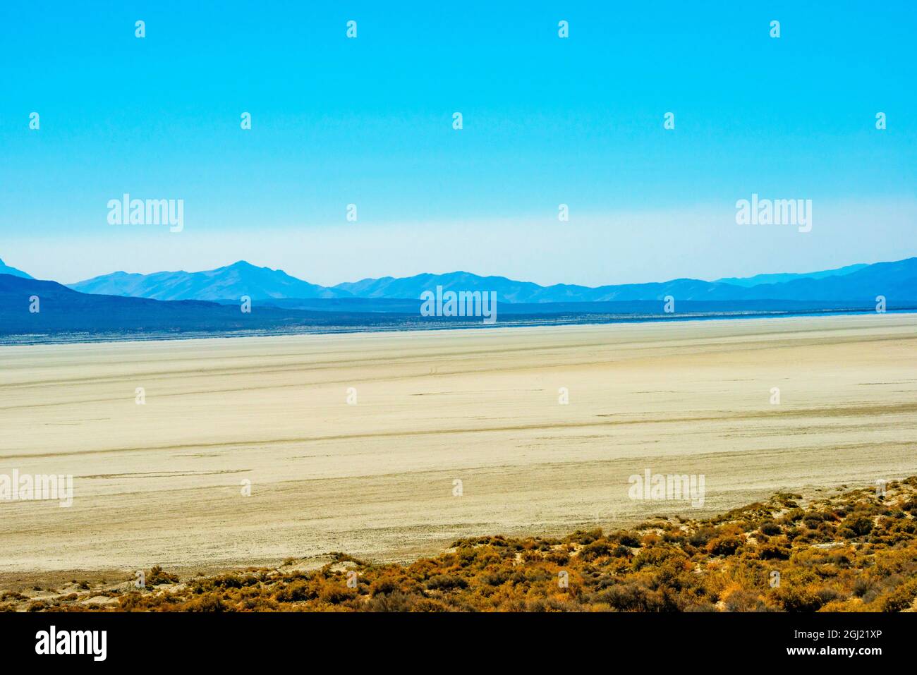 Estados Unidos, Nevada, Desierto de Black Rock, Playa polvorienta sobre el pincel de Sagebrush enmarcado por Kamma Mountain Range Foto de stock