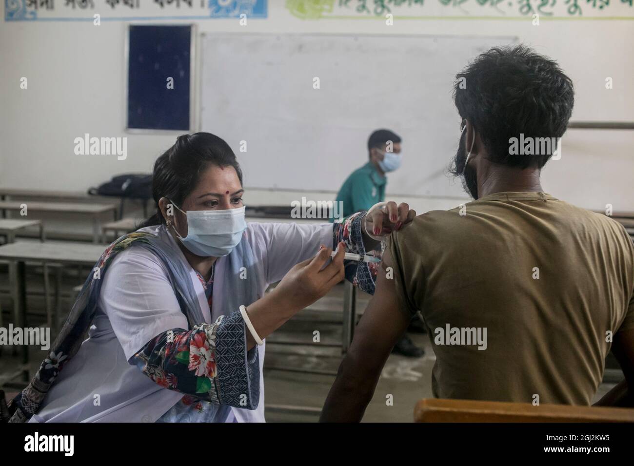 Dhaka, Bangladesh. 08th de Sep de 2021. Un trabajador de salud administra una dosis de la vacuna Moderna COVID19 a un hombre durante una campaña de vacunación en un centro de vacunación en Dhaka.Los residentes de Bangladesh se reúnen en gran número en la Escuela Primaria del Gobierno Mohammadpur, un centro de vacunación designado en Dhaka para recibir una dosis de vacunación Covid-19, Un segundo día en la campaña de vacunación masiva que comenzó el 7 de septiembre y terminará el 12th. Crédito: SOPA Images Limited/Alamy Live News Foto de stock